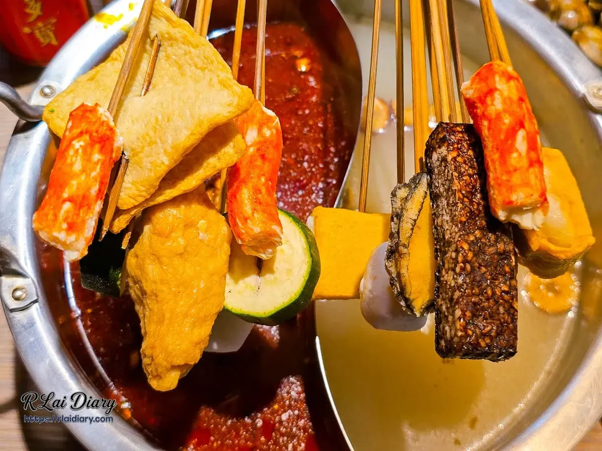 將多串食材放入麻辣鴛鴦鍋中烹煮的誘人畫面