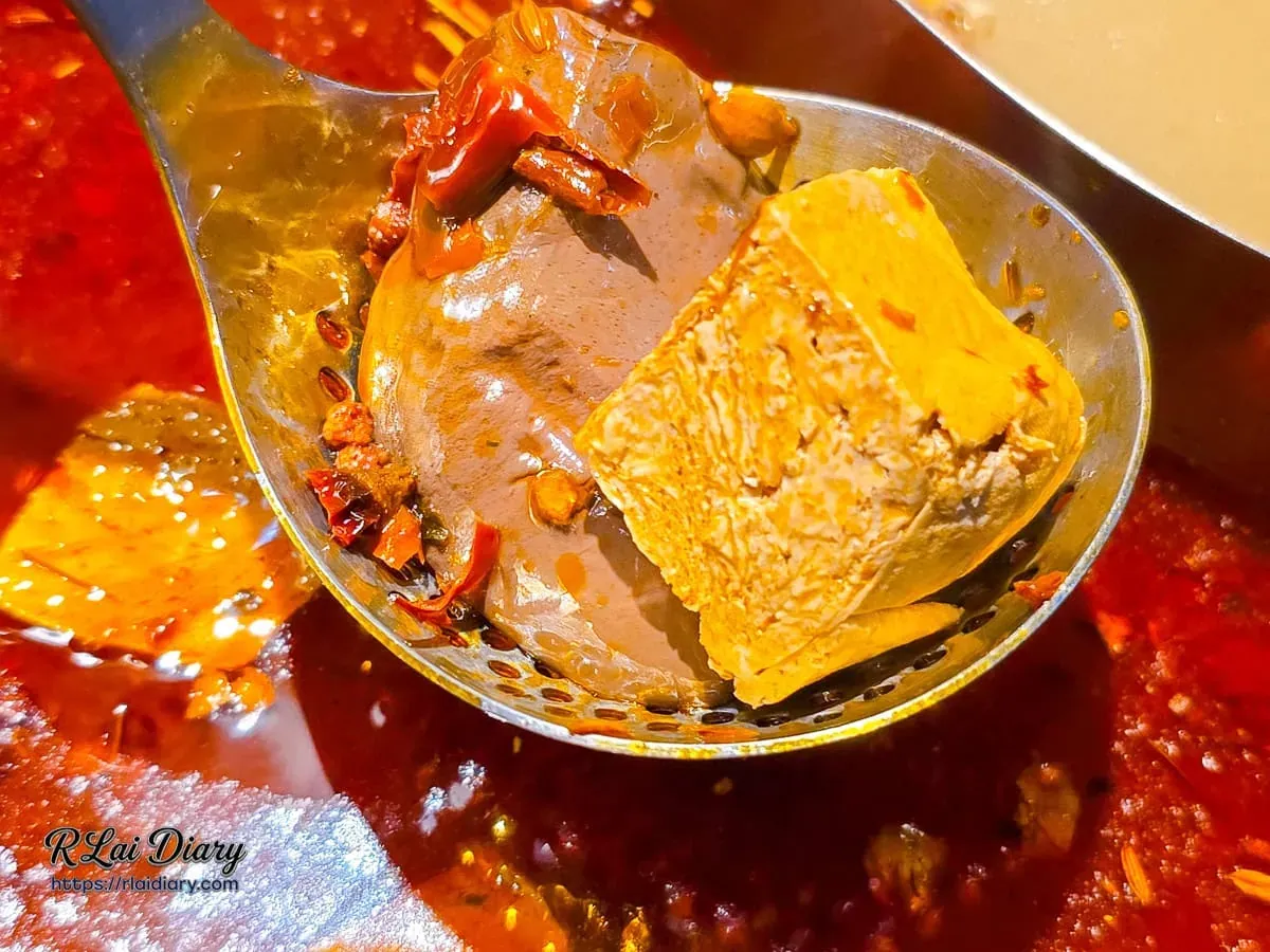 麻辣鍋底撈起入味的軟嫩鴨血與豆腐