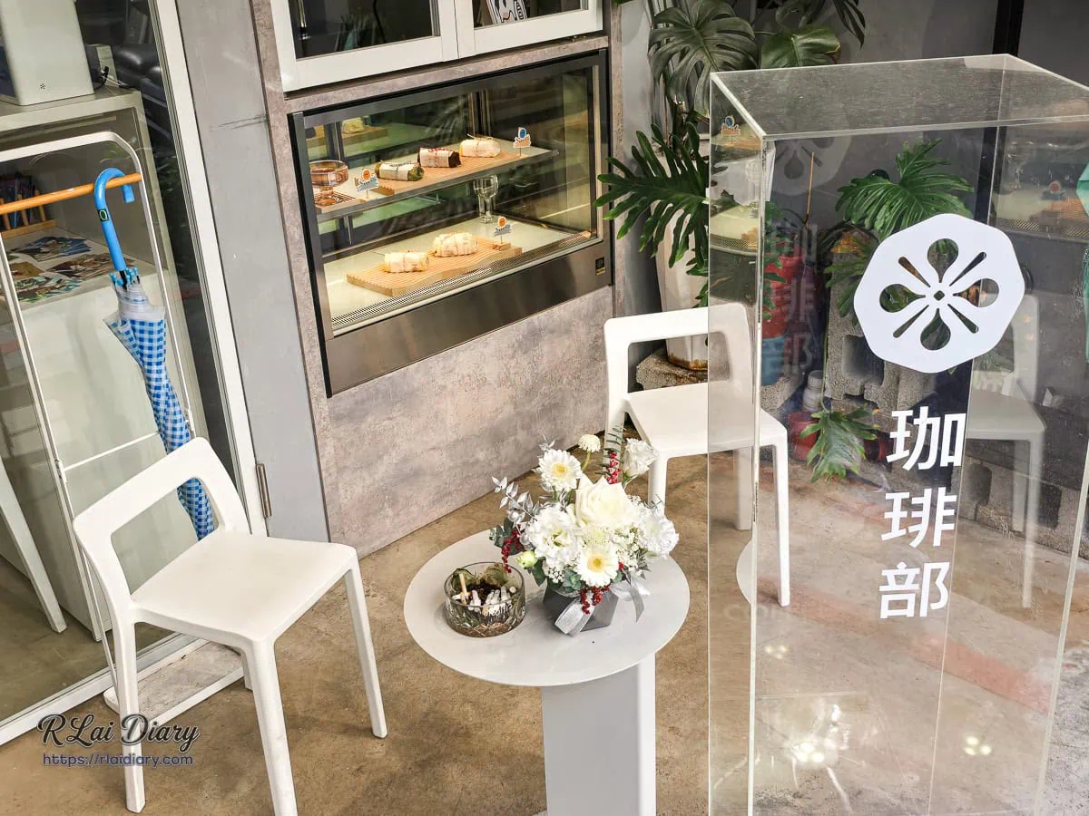 珈琲部門口的戶外座位區，有透明招牌與花藝點綴，適合展示甜點