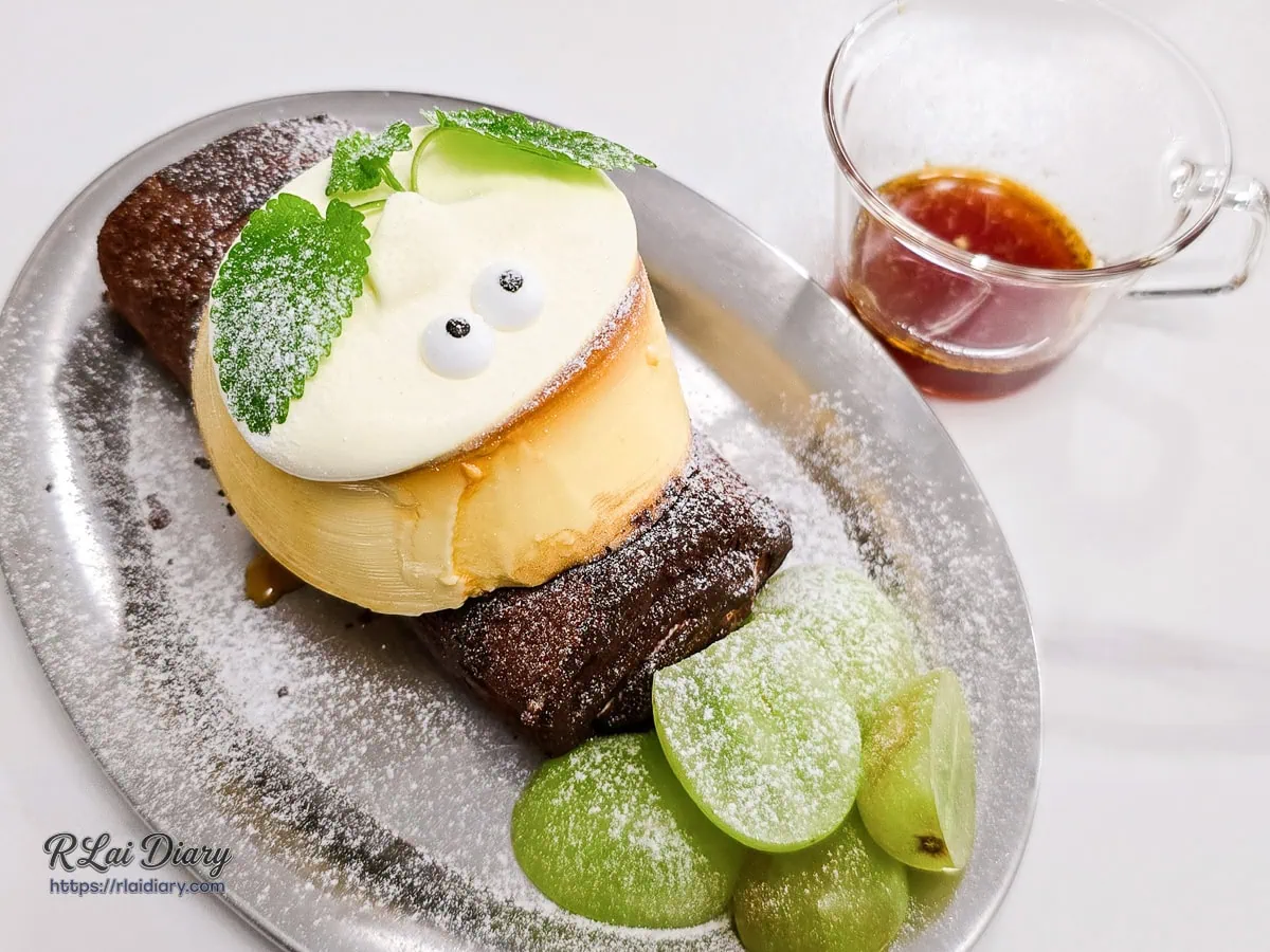 蝸牛毛巾捲盤飾完整呈現，一旁附有提味用的糖漿或醬汁