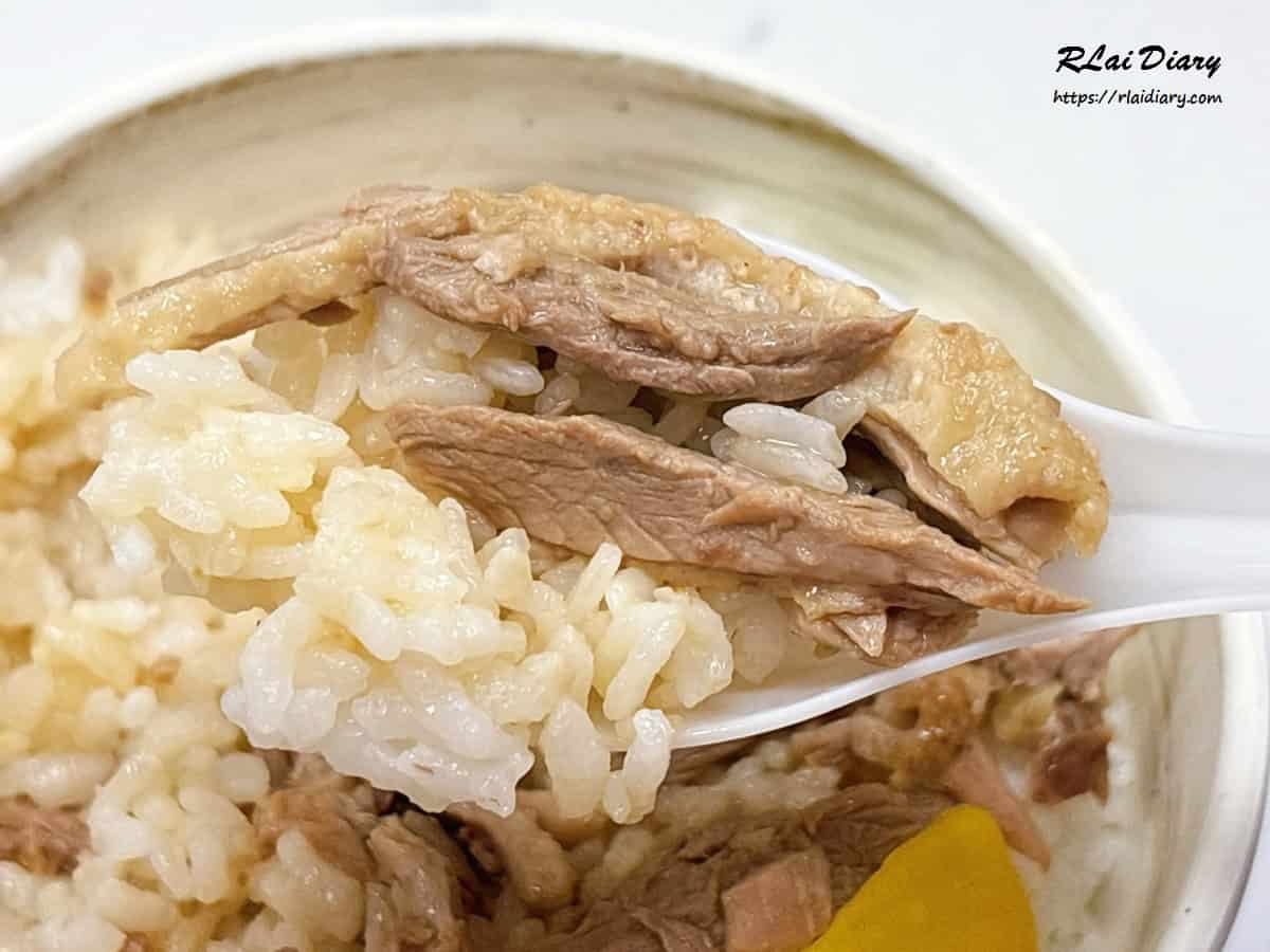 湯匙舀起村村食堂鴨肉飯，鴨肉香氣與清爽醬汁的完美搭配