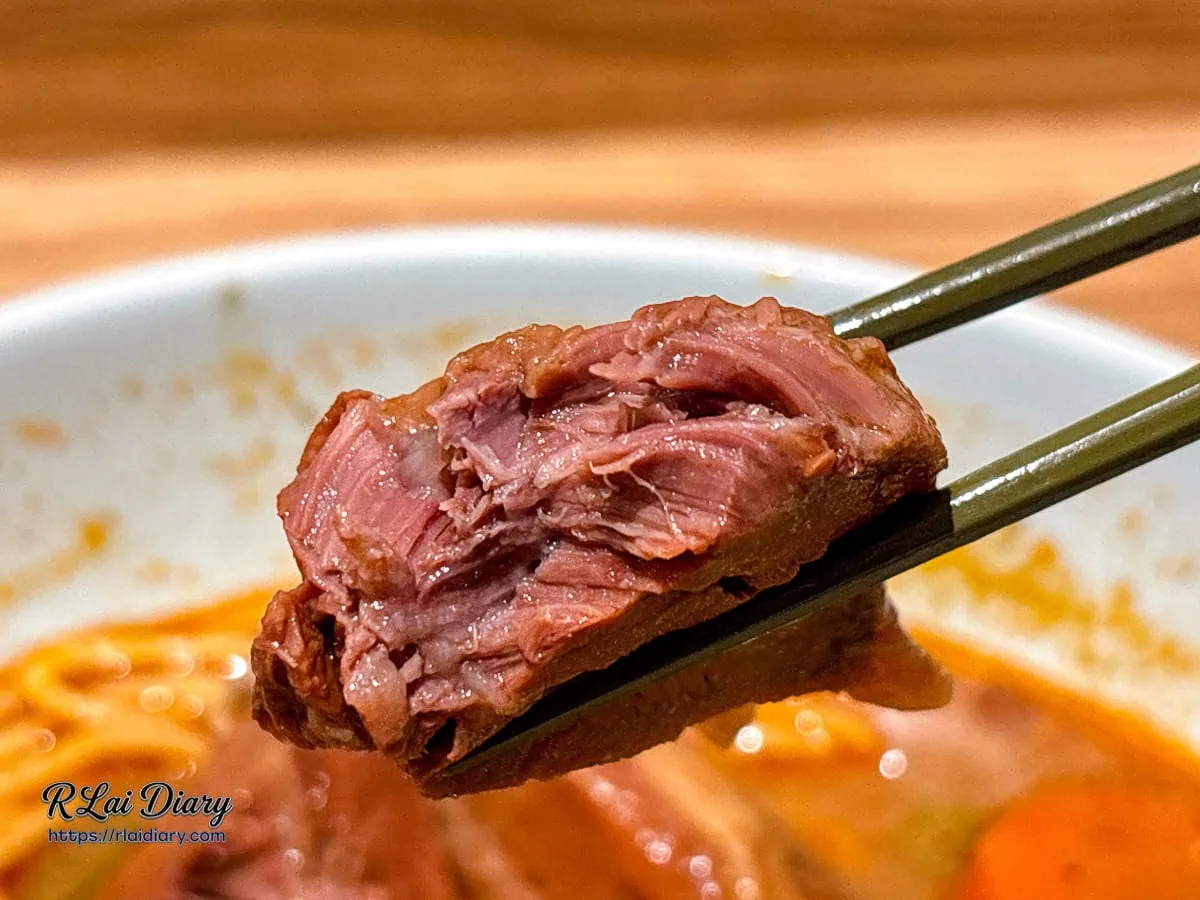 咬開後的牛腱肉特寫，展示肉質鮮嫩多汁的紋理