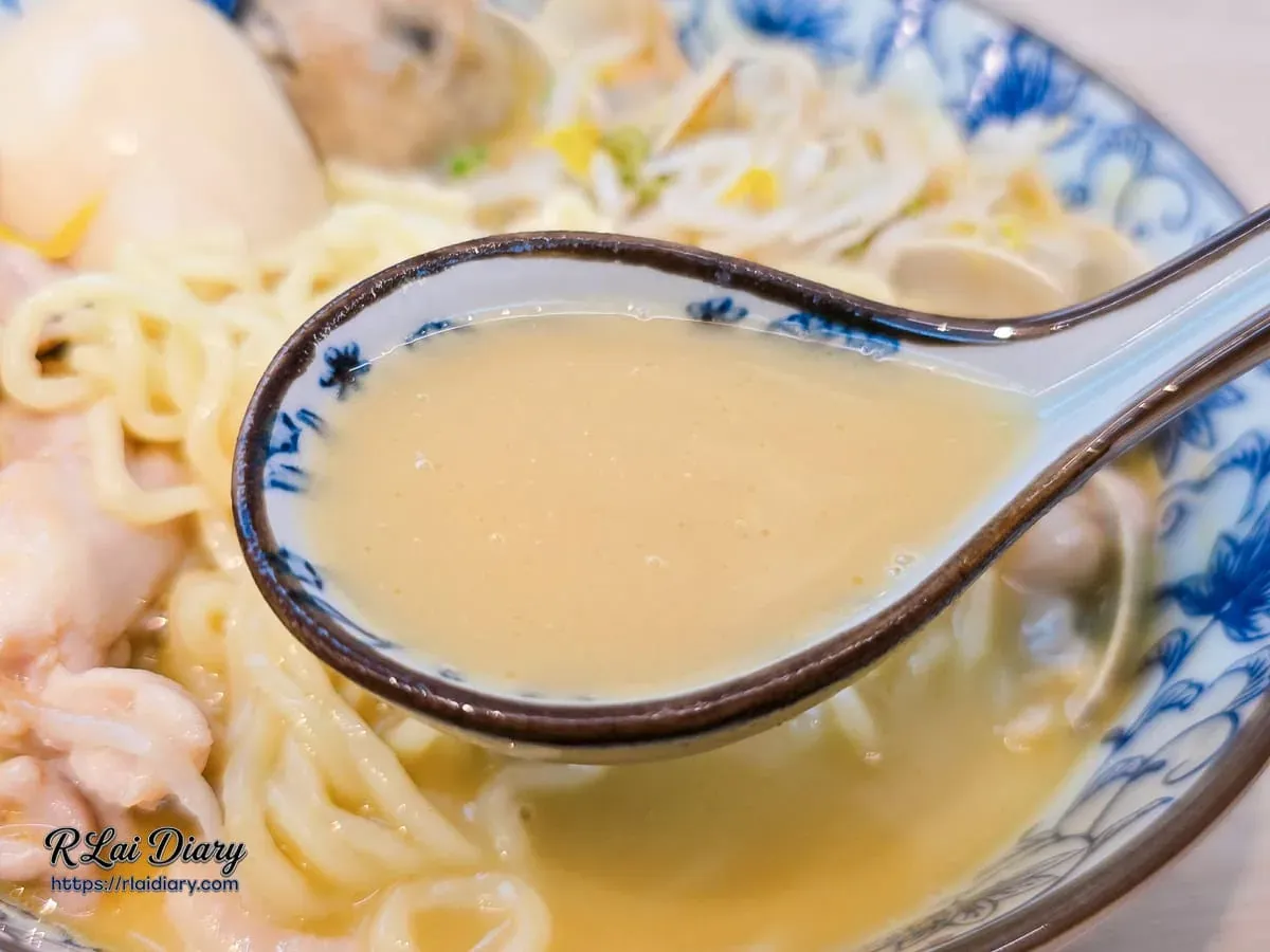 湯匙舀起金黃色的老母雞濃湯，湯頭濃郁醇厚