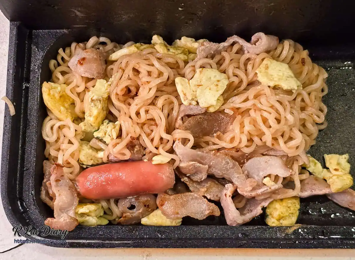 鐵板創意炒泡麵，加入肉片與醬汁快炒香氣四溢