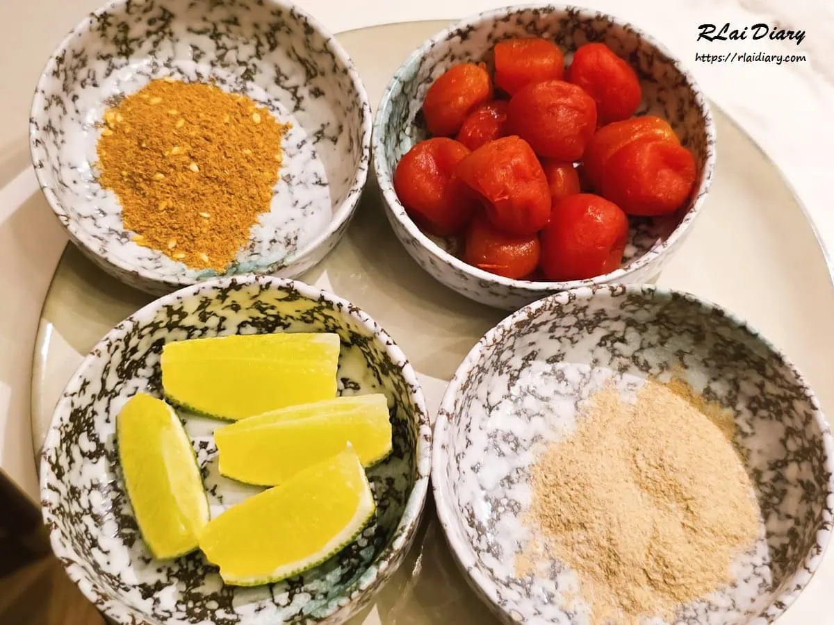 弎弎椒妃脆皮雞的特製配料，包含香辣椒碎、醃漬小番茄、檸檬角與乾碟粉