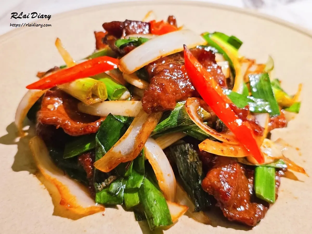 火爆蔥香牛特寫，醬色油亮且口感柔嫩的牛肉片，展現大火快炒的鑊氣