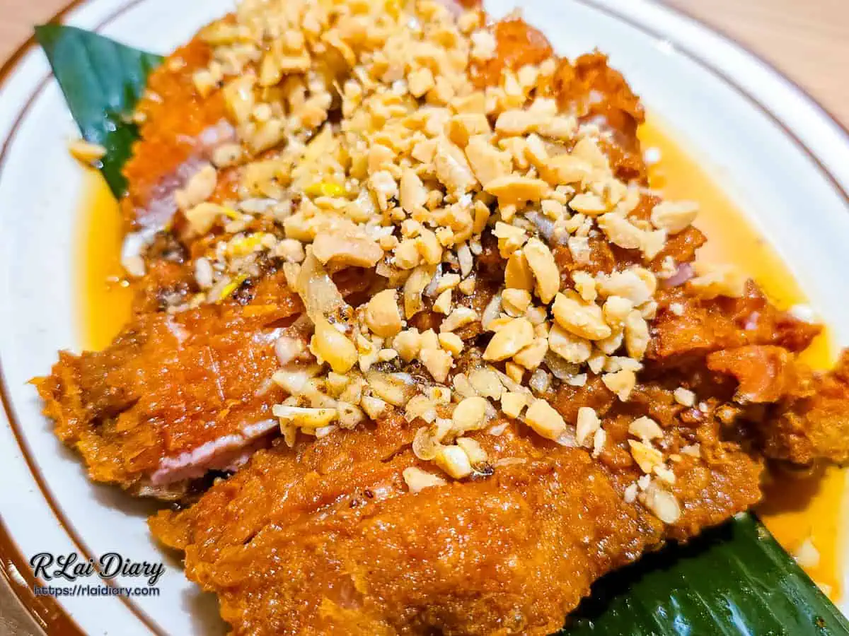 椒麻雞側面特寫，展示酥脆外皮與厚實多汁的雞腿肉