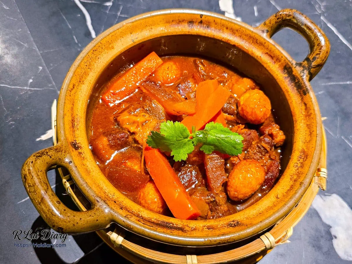 焦香椰汁瓦鍋豬，陶鍋盛裝著滷至深紅色的紅燒肉與鵪鶉蛋，色澤誘人