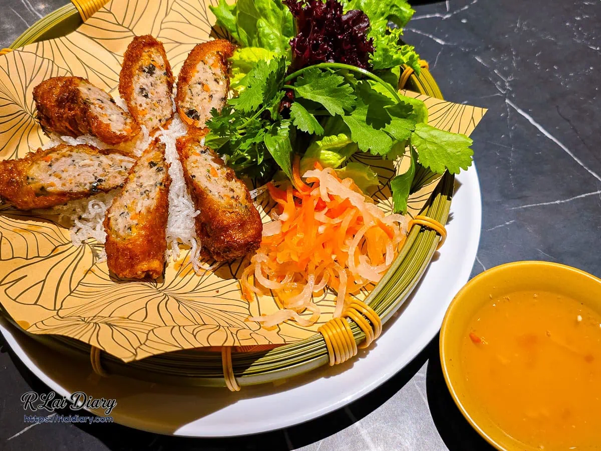 金酥炸春捲擺盤，金黃酥脆的春捲切段，搭配生菜、醃蘿蔔與特製魚露