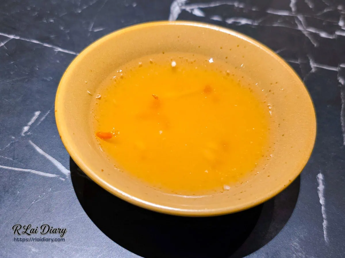 特製檸檬魚露沾醬特寫，呈現清透的琥珀色澤與辣椒點綴