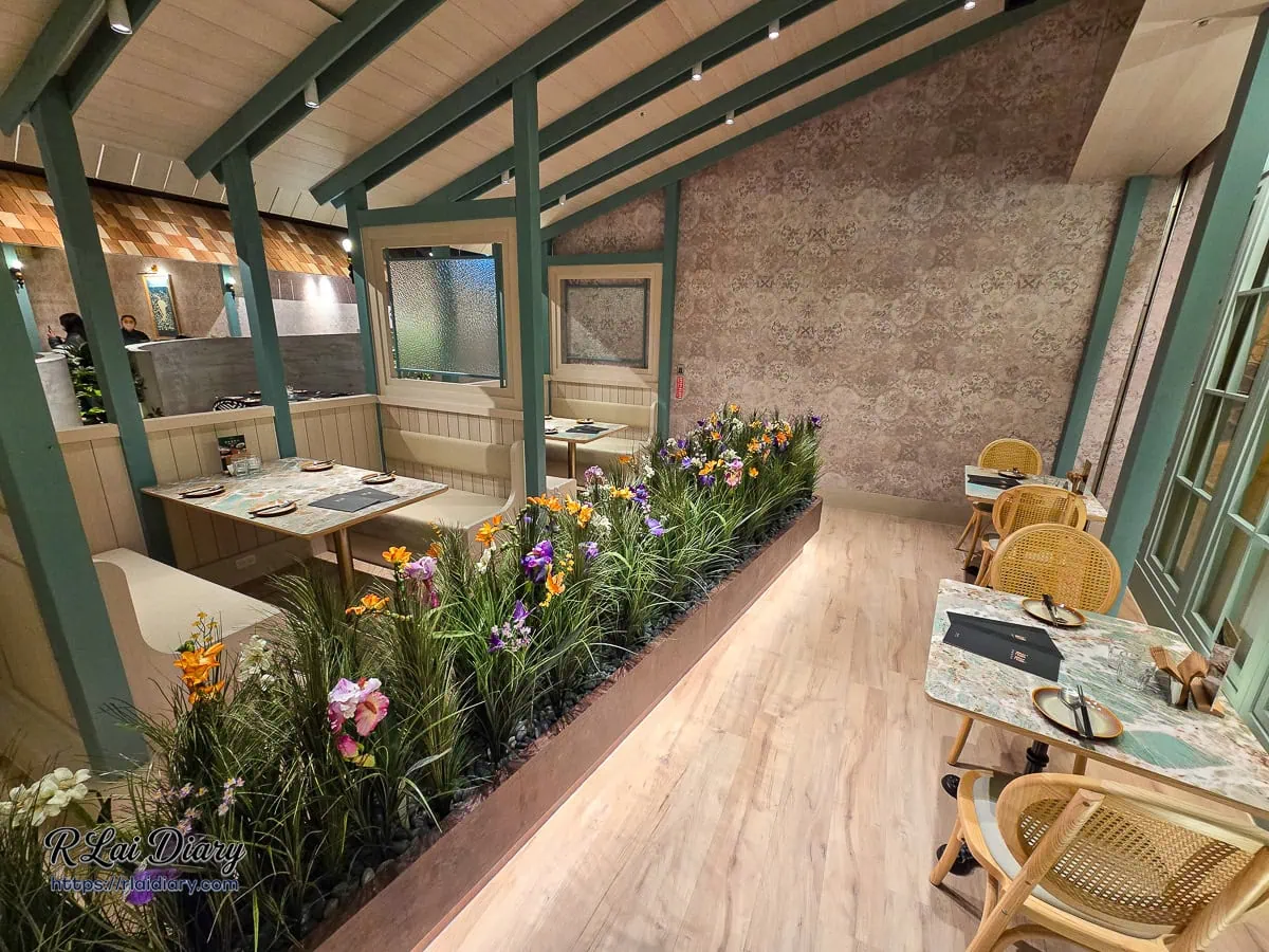 充滿綠意的長廊座位區，兩側種植花草植栽，營造室內庭園的舒適感