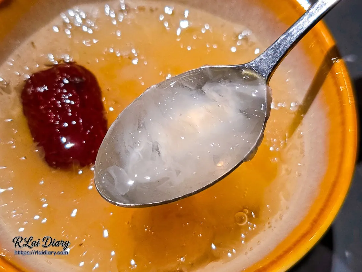 湯匙舀起燉煮至軟爛的白木耳，膠質豐富，口感滑順