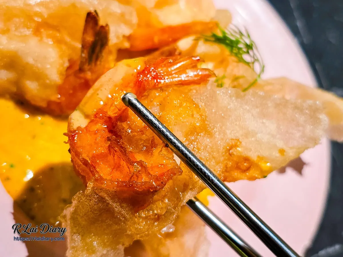 夾起一塊米紙雲朵蝦，透光的酥脆外皮與隱約可見的鮮蝦內餡