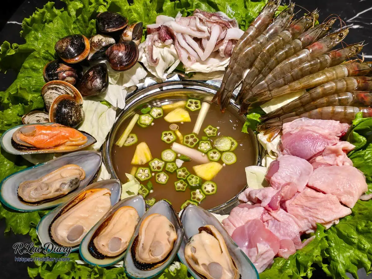 海陸推推鍋，帽子鍋緣鋪滿鮮蝦、蛤蠣、淡菜、透抽與雞肉，中央是湯底