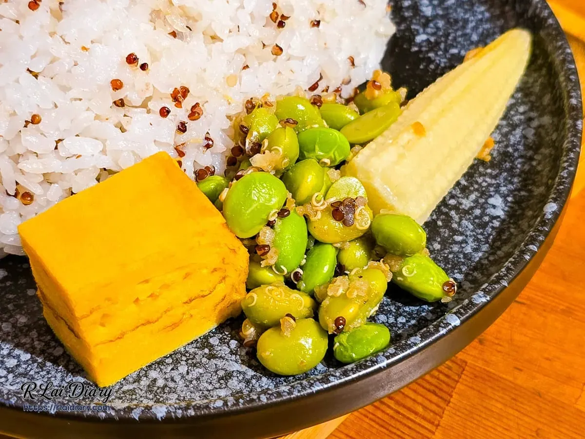 咖哩飯配菜特寫，包含毛豆藜麥沙拉、玉米筍與玉子燒
