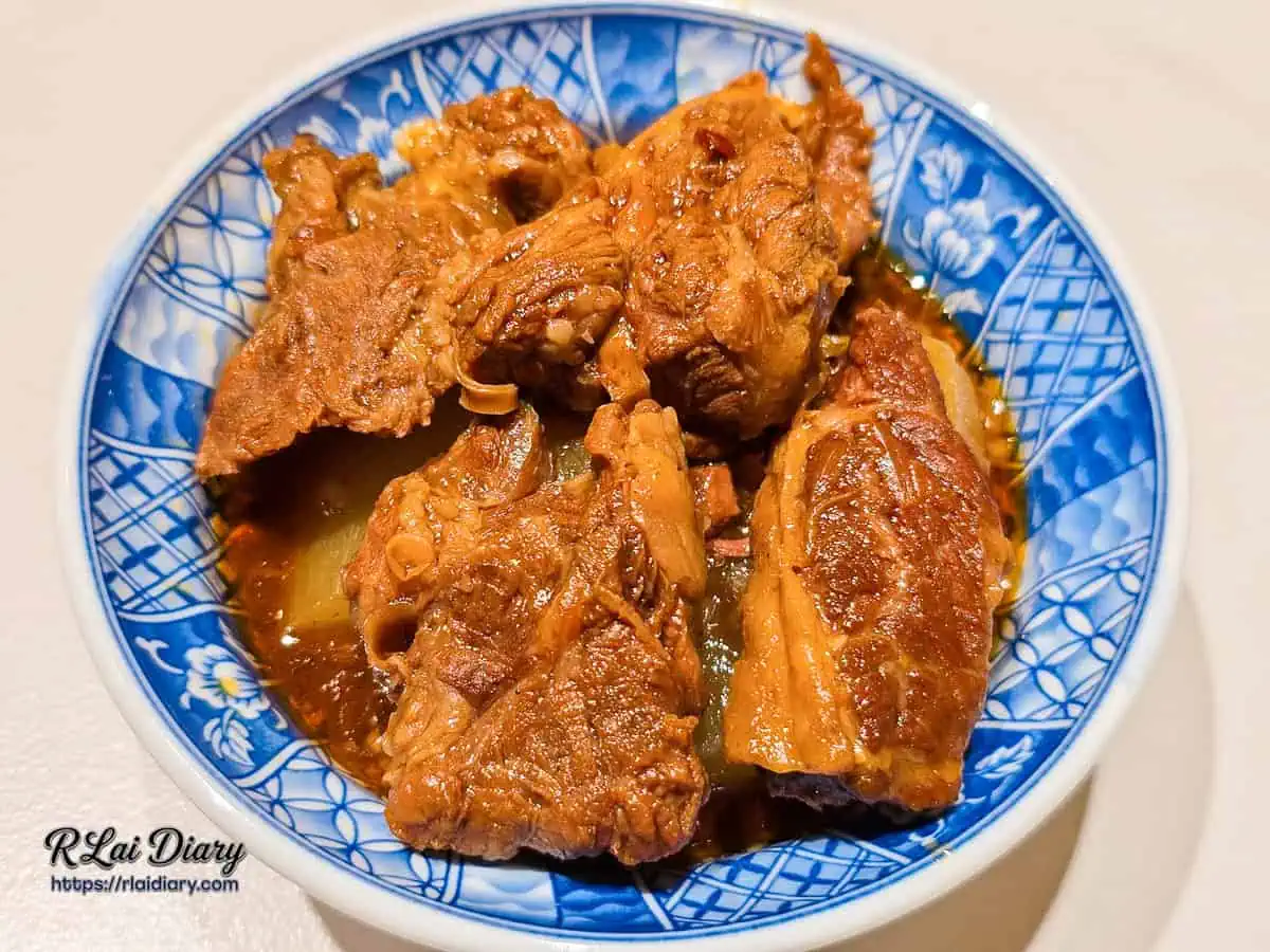 大力黑金滷肉飯以復古青花瓷碗盛裝的爆汁紅燒牛腩與蘿蔔塊俯視圖。