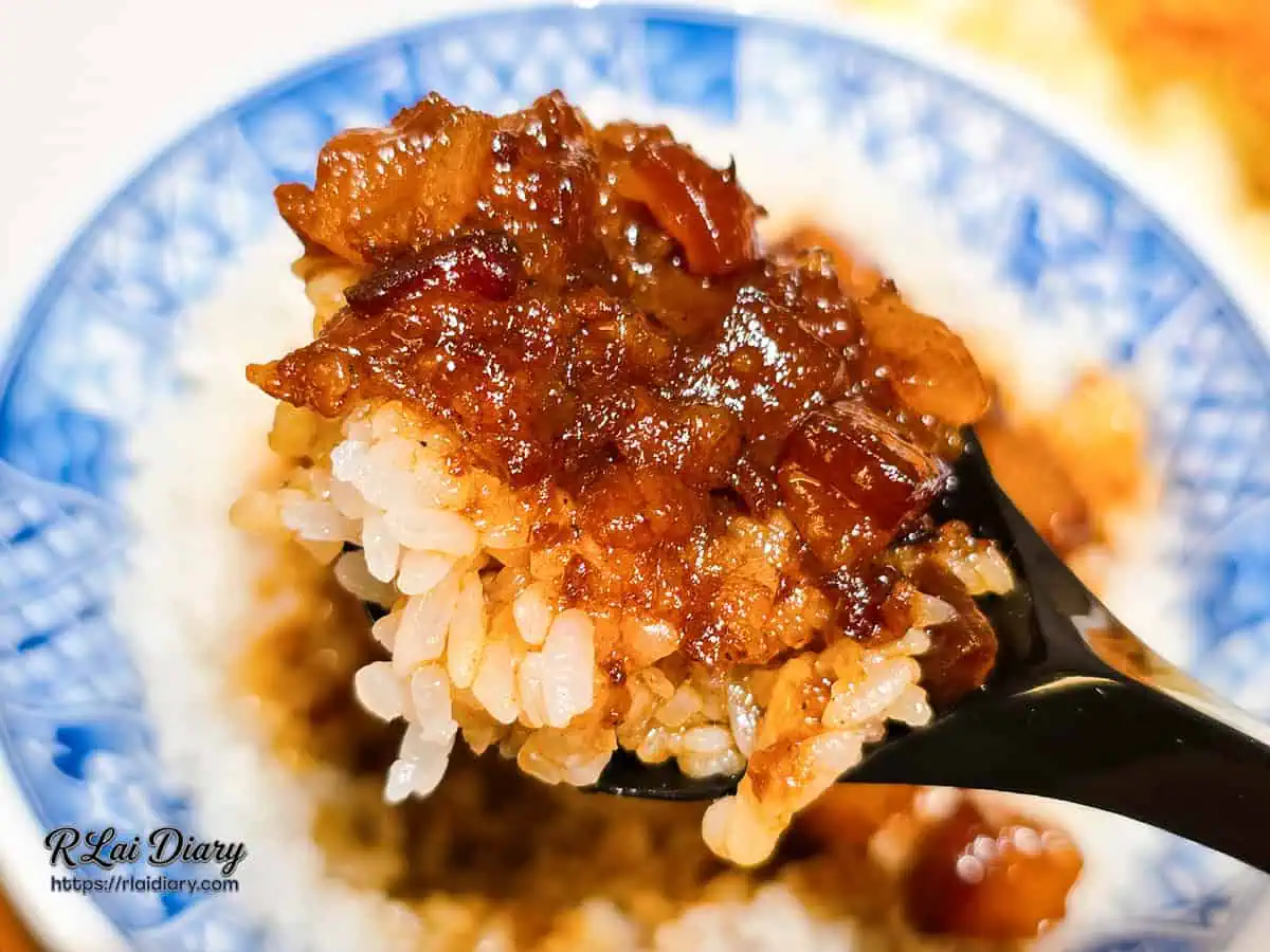 大力黑金滷肉飯黑湯匙舀起滿滿一口，醇厚甘甜的黑金滷汁完美包覆Q彈白米飯的視角。