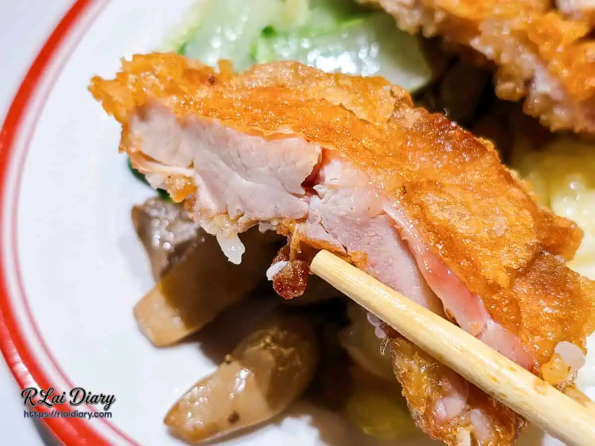 大力黑金滷肉飯香酥去骨雞腿肉斷面秀，筷子夾起展現皮薄肉厚、飽滿多汁的肉質。