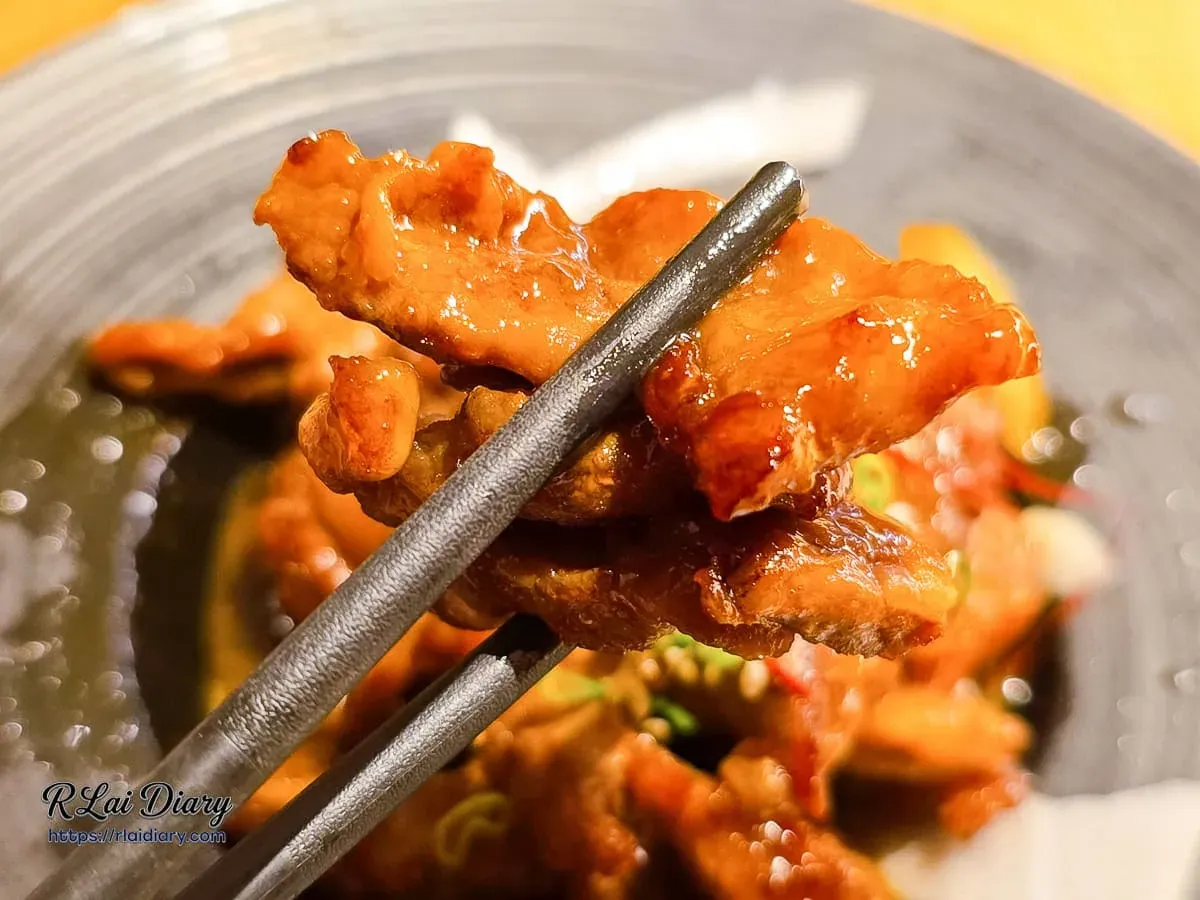 台中丹丘たんきう牛肉燒肉風，筷子夾起油亮多汁且裹滿濃郁醬汁的軟嫩牛肉片
