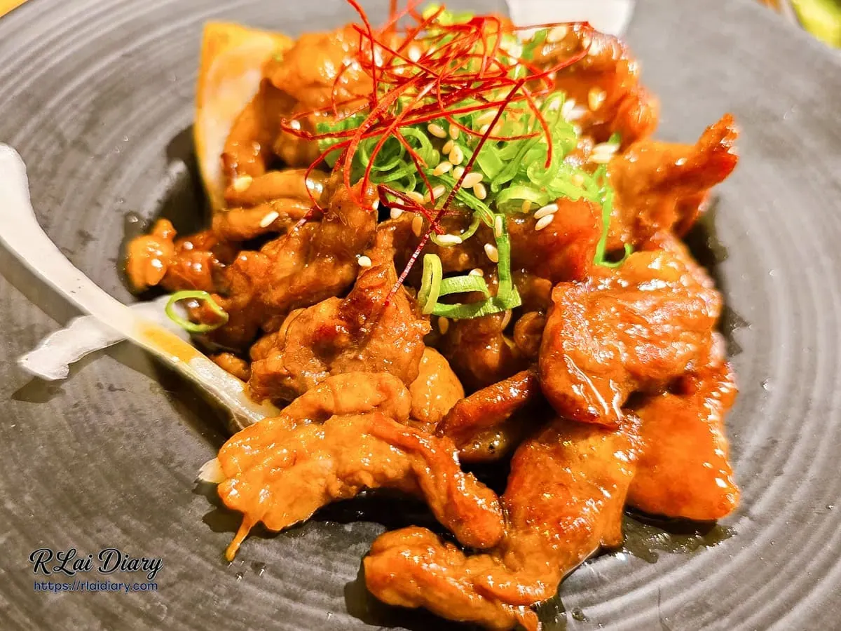 台中丹丘たんきう牛肉燒肉風特寫，焦糖色澤牛肉片點綴翠綠蔥花、辣椒絲與白芝麻