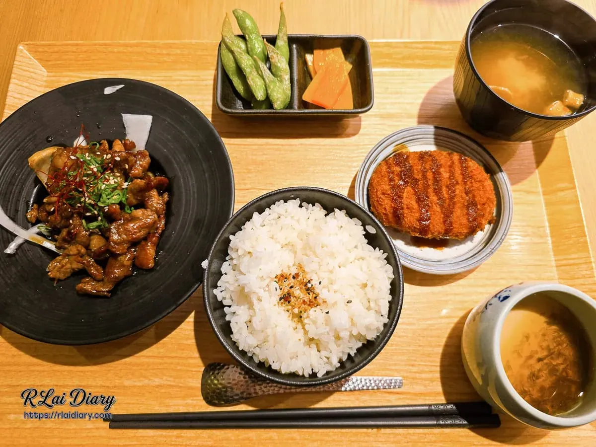 台中丹丘たんきう牛肉燒肉風定食全貌，木托盤盛裝主食、香米飯、可樂餅、茶碗蒸與小菜
