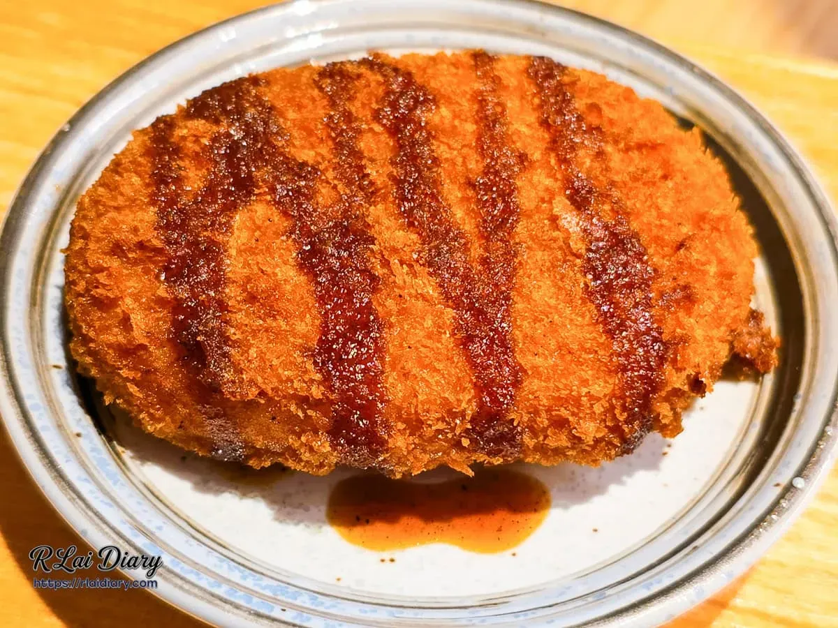 台中丹丘たんきう單點日式可樂餅，金黃酥脆外衣淋上微酸微甜的特製日式豬排醬