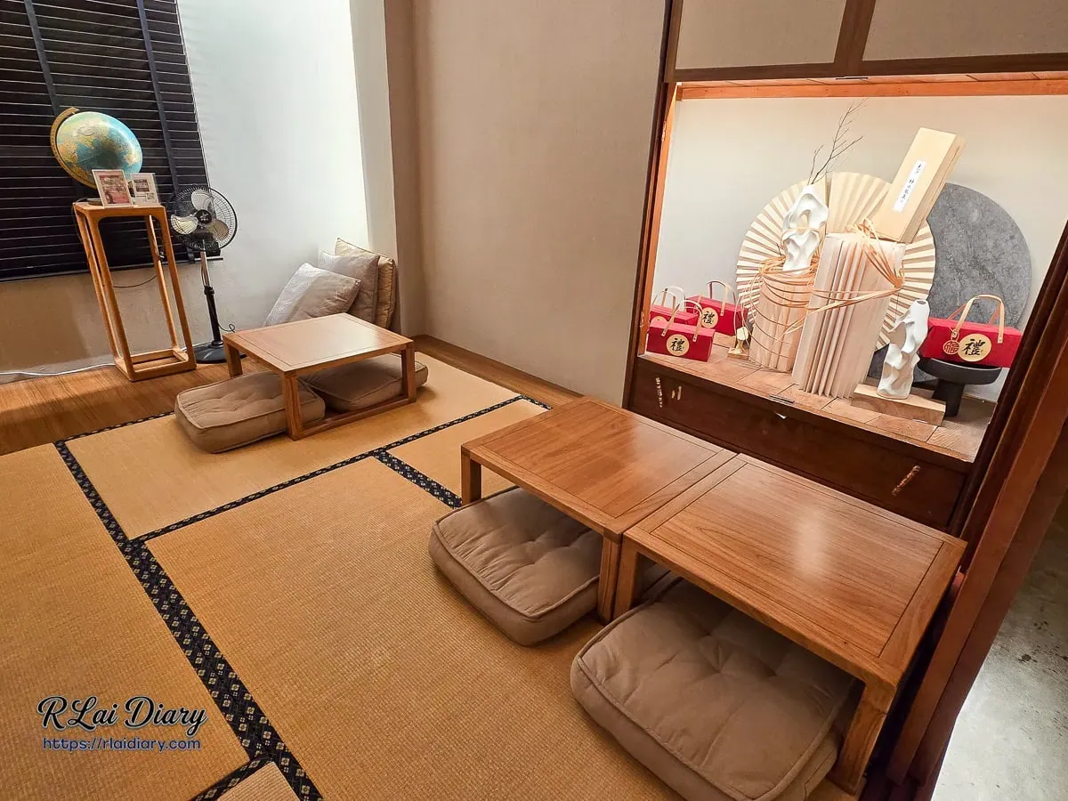 台中丹丘たんきう二樓榻榻米座位區，和風展示櫃結合紙扇花藝與復古地球儀增添雅致氛圍