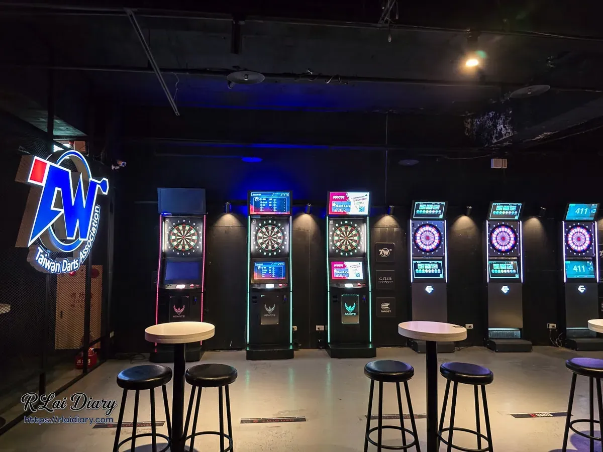 G CLUB TAIPEI 閃爍科技霓虹光的電子飛鏢機台區，牆面掛有台灣飛鏢協會標誌