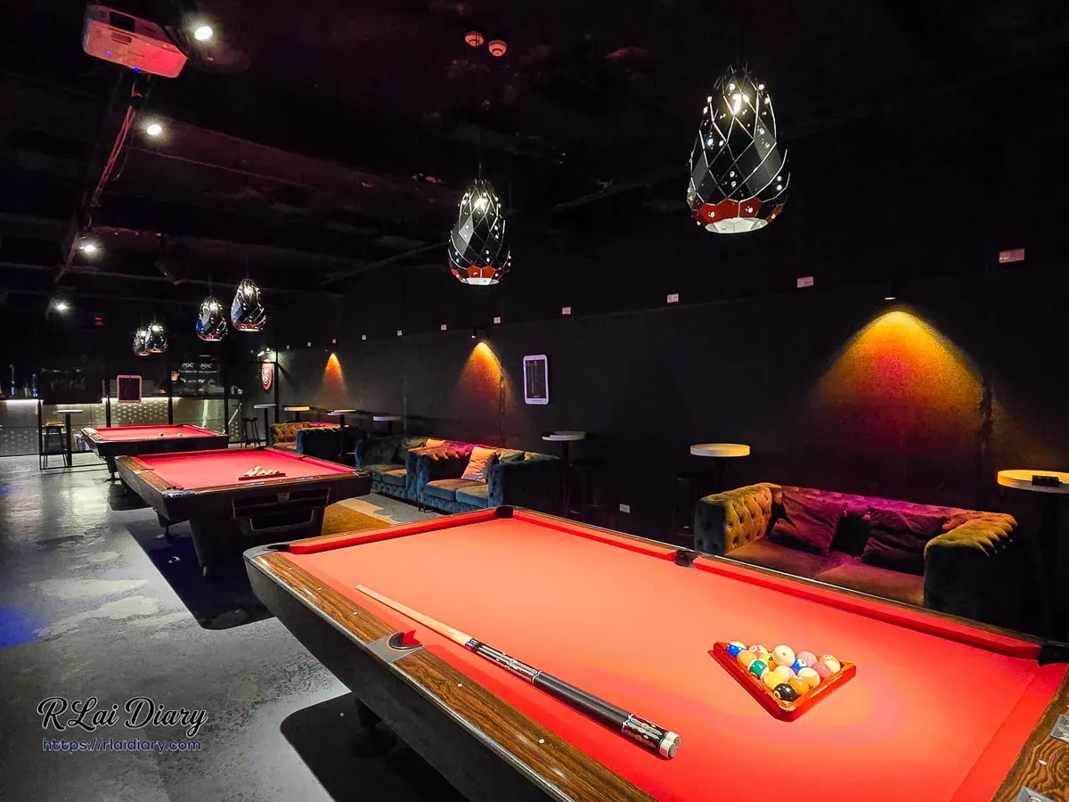 G CLUB TAIPEI 店內的高質感酒紅色絨布撞球檯，搭配琥珀色燈光與復古皮沙發休息區