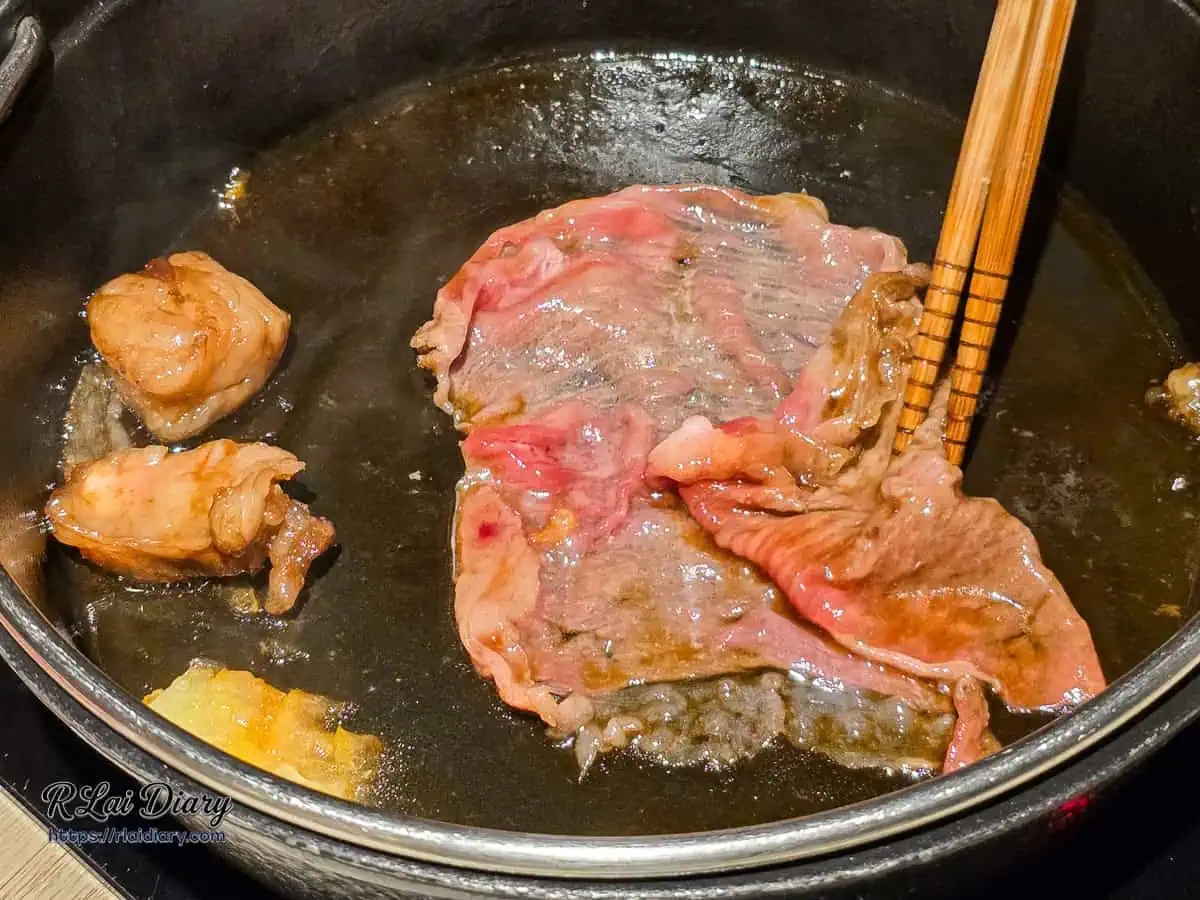 專人桌邊服務正在煎煮大片日本和牛，精準掌控壽喜燒肉片熟度
