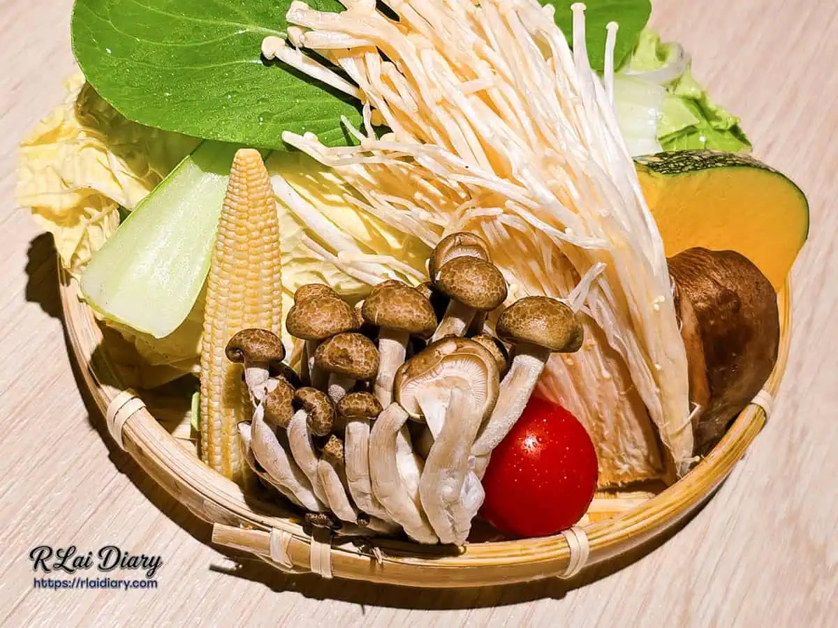 壽喜燒鍋底食材配置，包含金針菇、鴻喜菇、大白菜與玉米筍