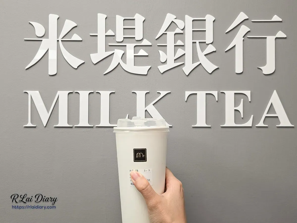 手持米堤銀行大安店質感外帶紙杯與牆面品牌英文字體合影