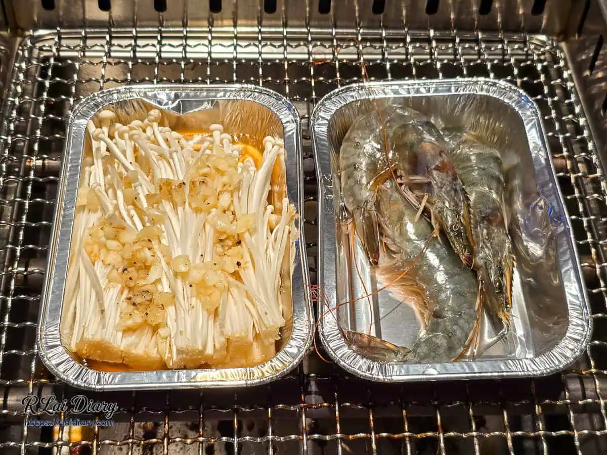 小蒙牛台中大里店火烤兩吃樂趣，將裝滿蒜香金針菇與蝦子的錫箔盒放上烤網，鎖住濃郁海味與鮮甜