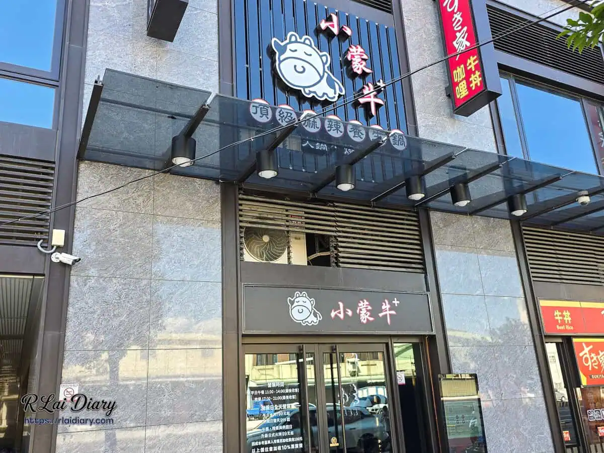 小蒙牛頂級麻辣鍋烤台中大里店外觀，沉穩灰階石材外牆與經典小牛招牌