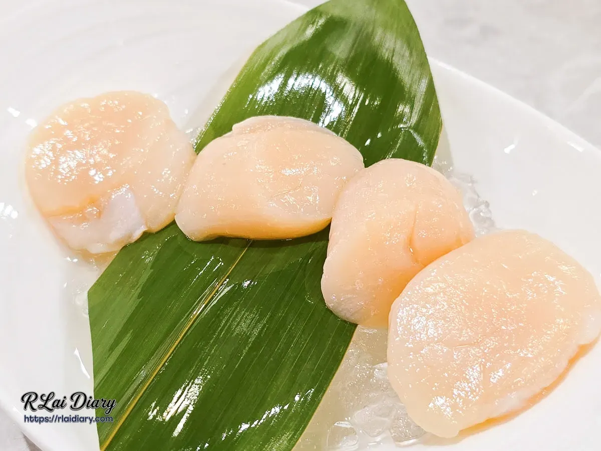 新肉多多台北忠孝店大干貝近照，展現干貝厚實飽滿的厚度與極佳的鮮度，底層鋪滿碎冰細心保鮮