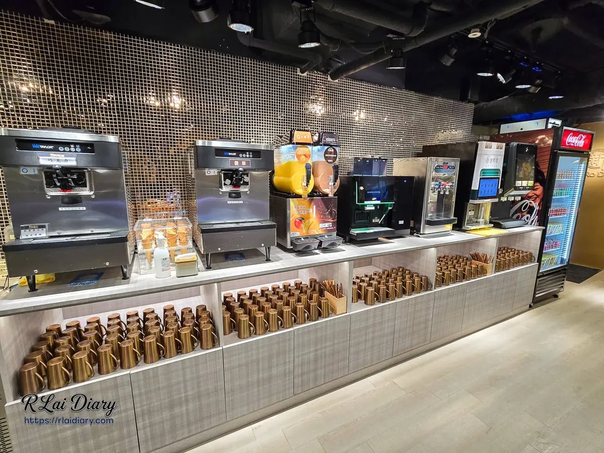 新肉多多台北忠孝店自助吧全景，金色馬賽克牆面搭配豐富飲品機台與質感玫瑰金水杯
