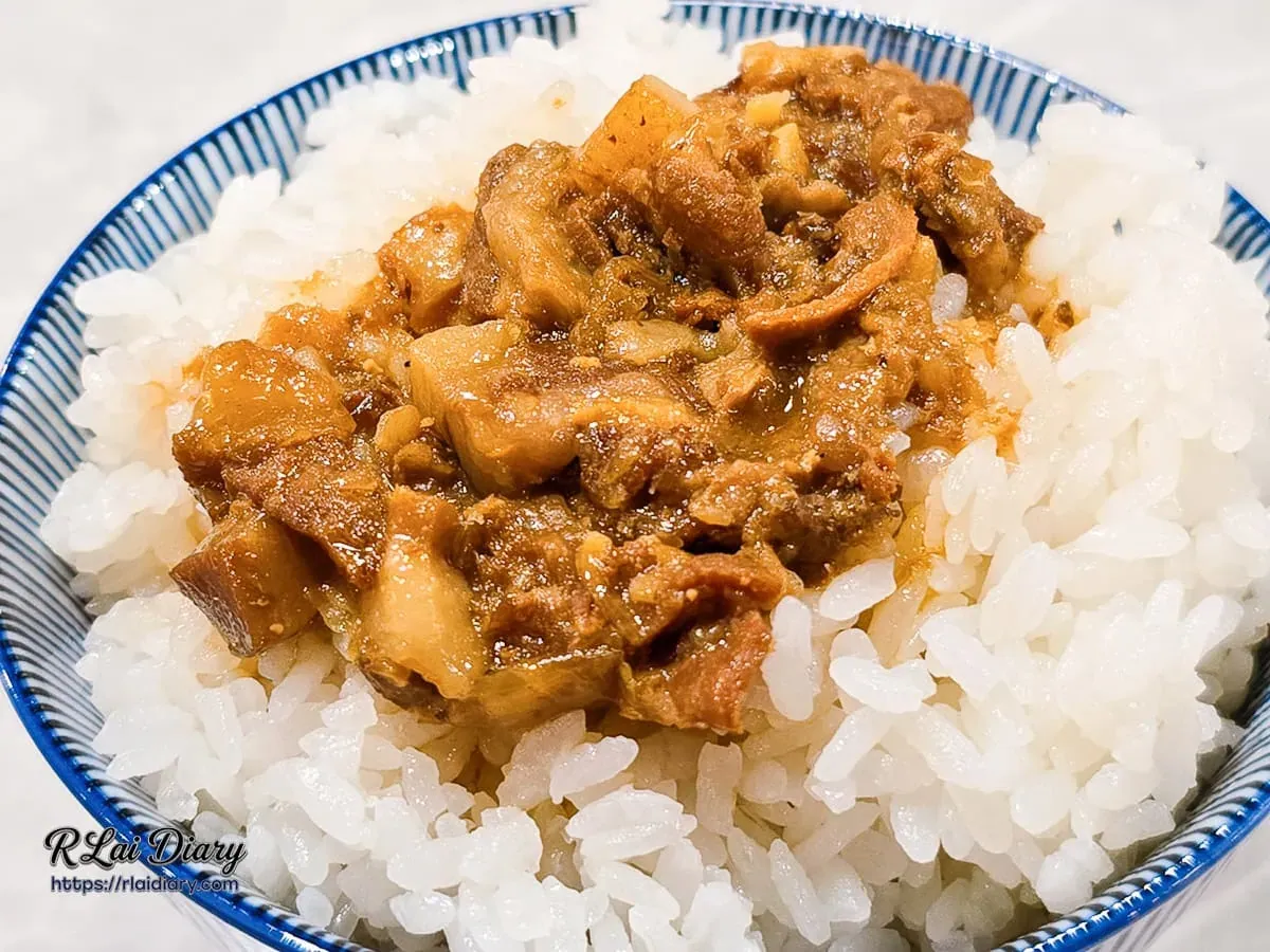 新肉多多台北忠孝店黃金粹滷飯近照，粒粒分明的飽滿白飯淋上琥珀色澤、富含膠質的牛豬雙拼滷汁