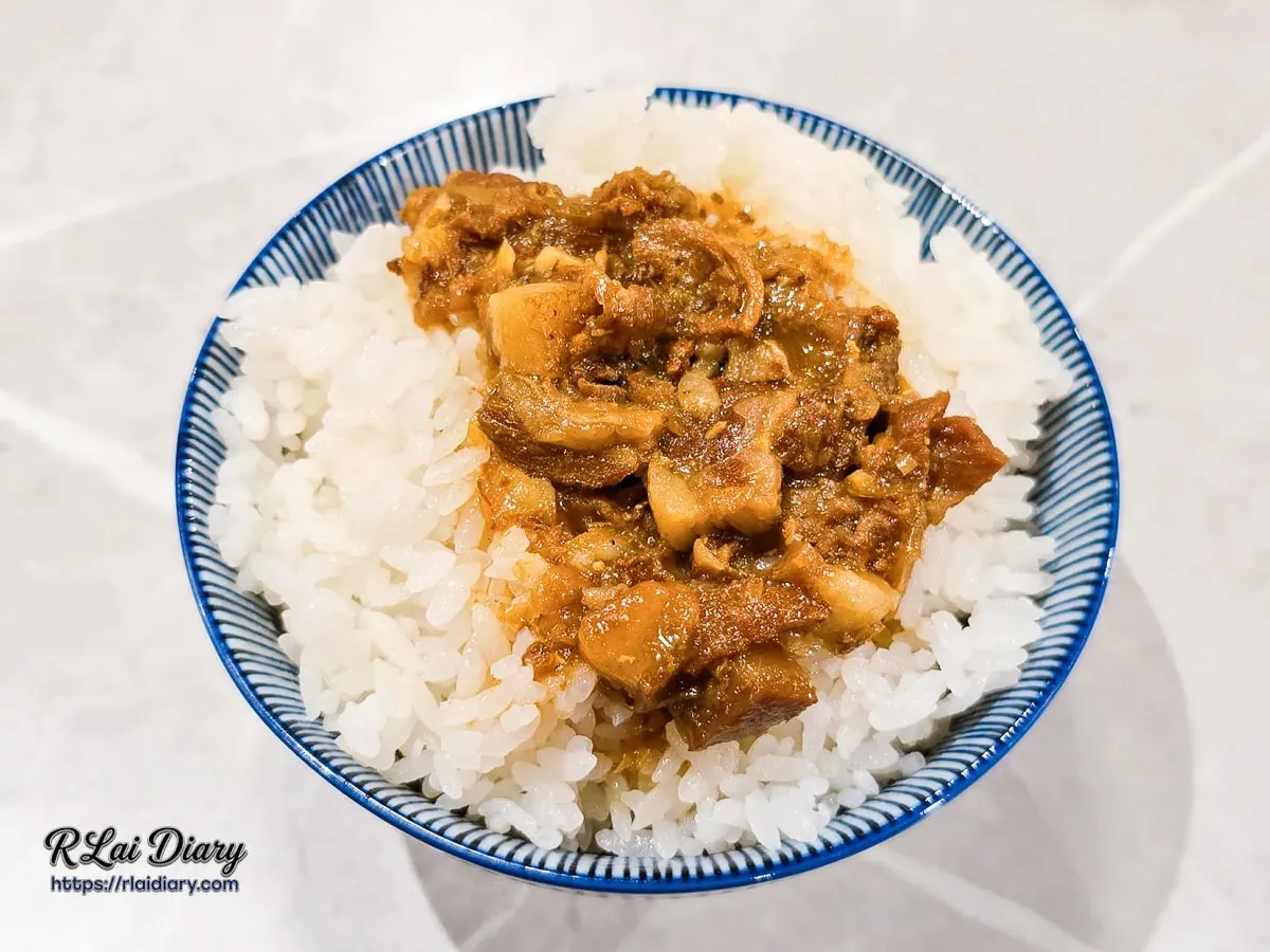 新肉多多台北忠孝店附餐黃金粹滷飯，油潤光澤的特製滷肉燥完美覆蓋在米飯上，盛裝於日式青花瓷碗