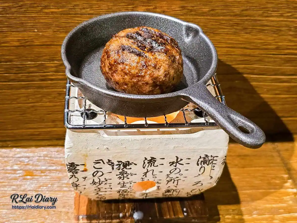 第二顆漢堡排放在迷你炭爐鐵碗中持續溫熱加熱