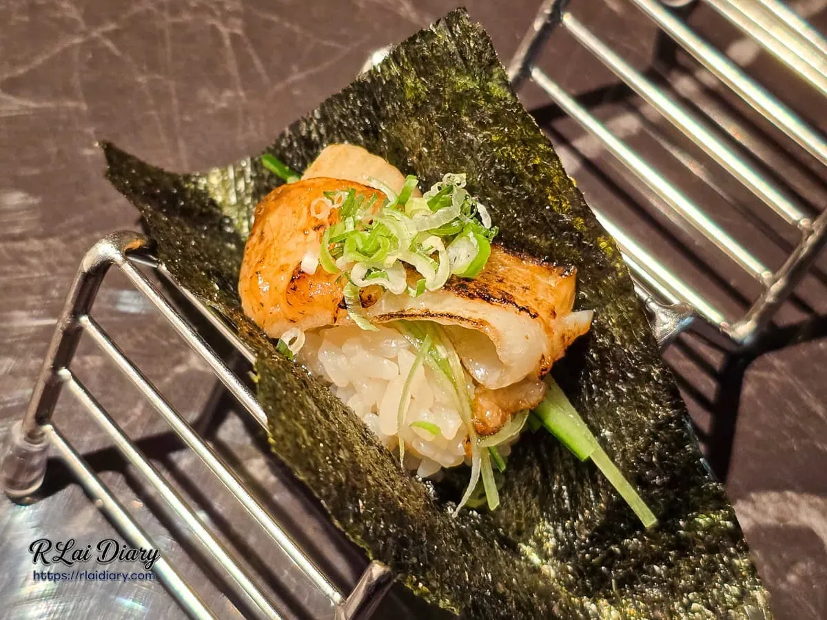 炙燒比目魚鰭邊肉手卷，放置於金屬架上的精緻日料