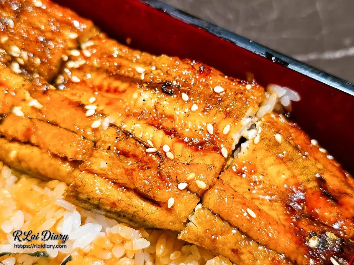 炭烤蒲燒鰻魚表面焦糖色澤與白芝麻細節特寫