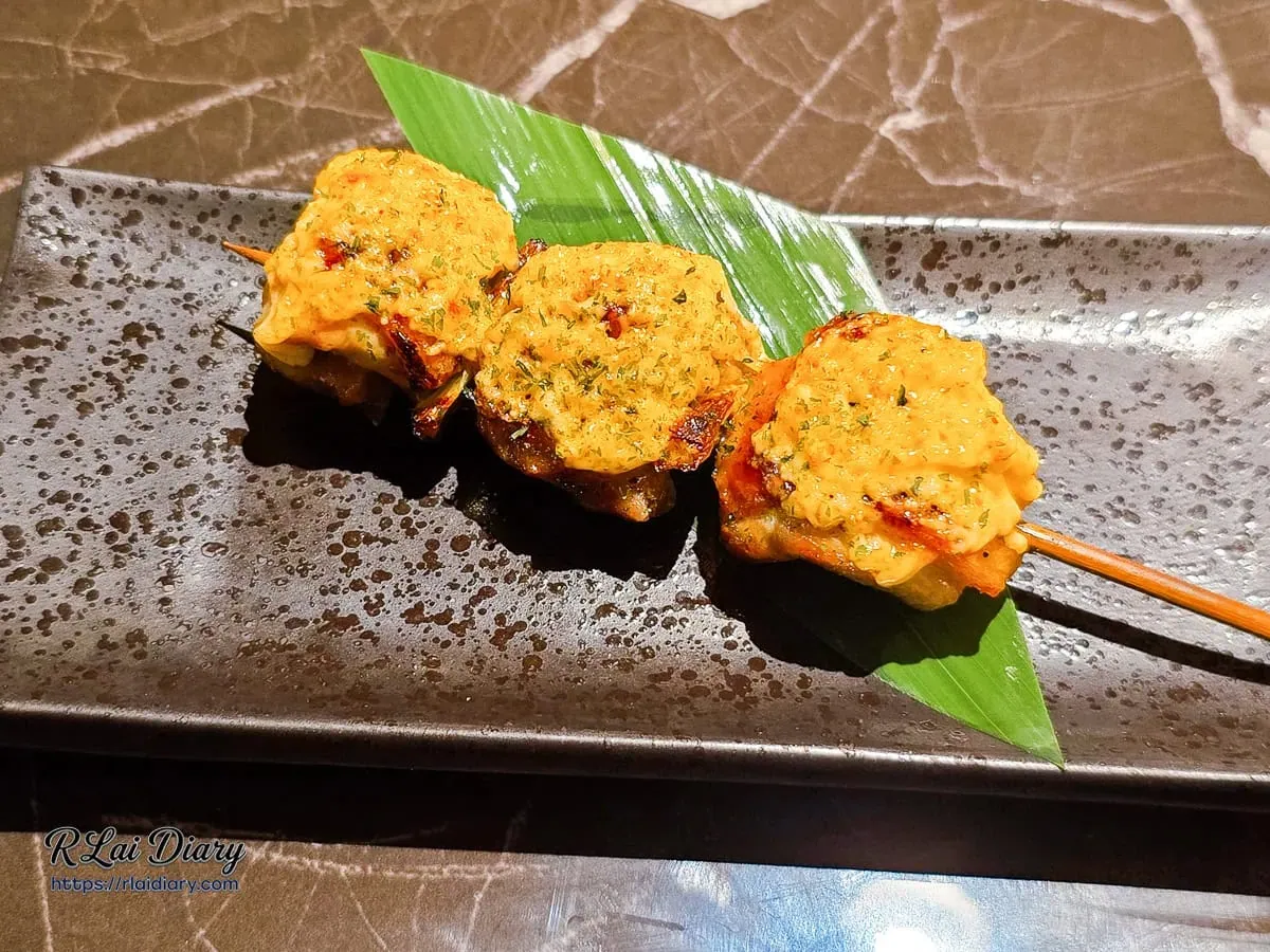 日式居酒屋必吃雞肉丸串燒，表面炙燒明太子醬汁