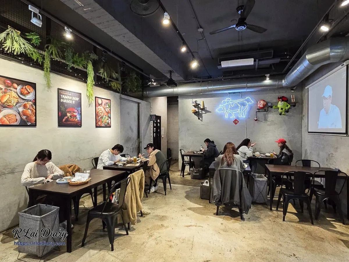 店內用餐空間寬敞，牆面霓虹燈裝飾與投影幕氛圍