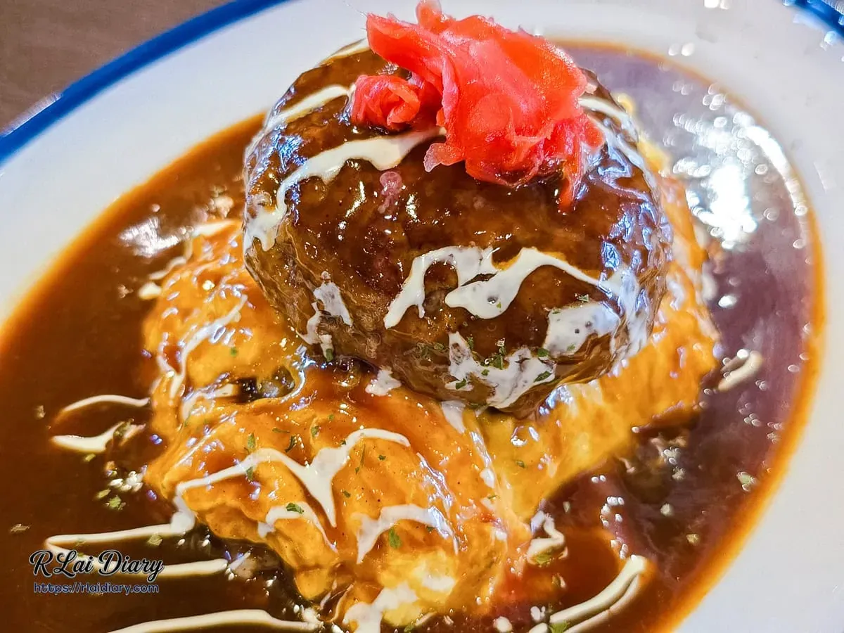 近距離拍攝滑蛋漢堡排飯，淋上濃郁多蜜醬汁