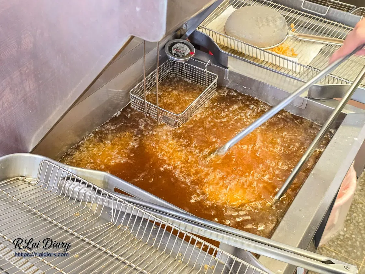 騰之雞排現點現做炸油特寫：清澈透亮的琥珀色熱油與發亮的不鏽鋼設備，展現店家對食安與衛生的極致要求