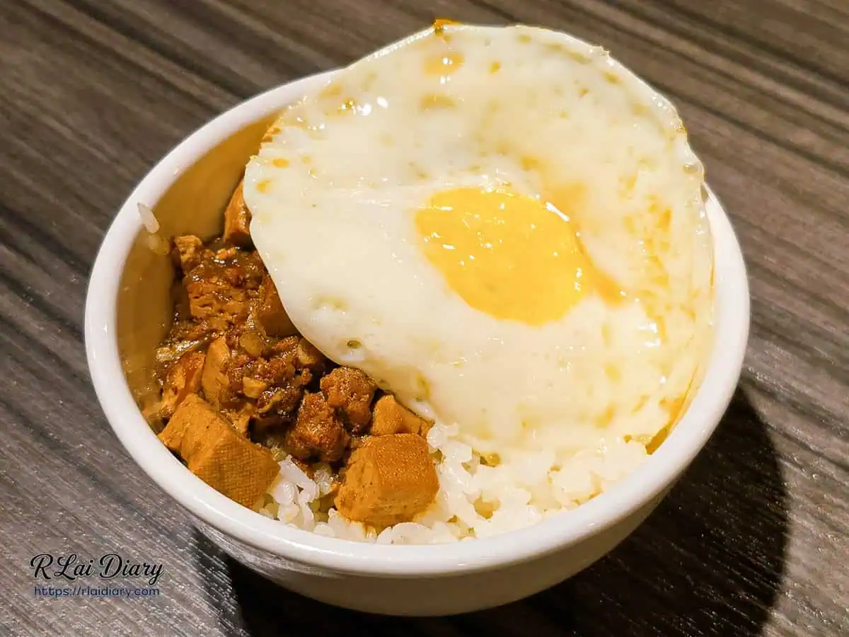 滷肉飯加上半熟荷包蛋，金黃蛋液流出拌飯的美味瞬間