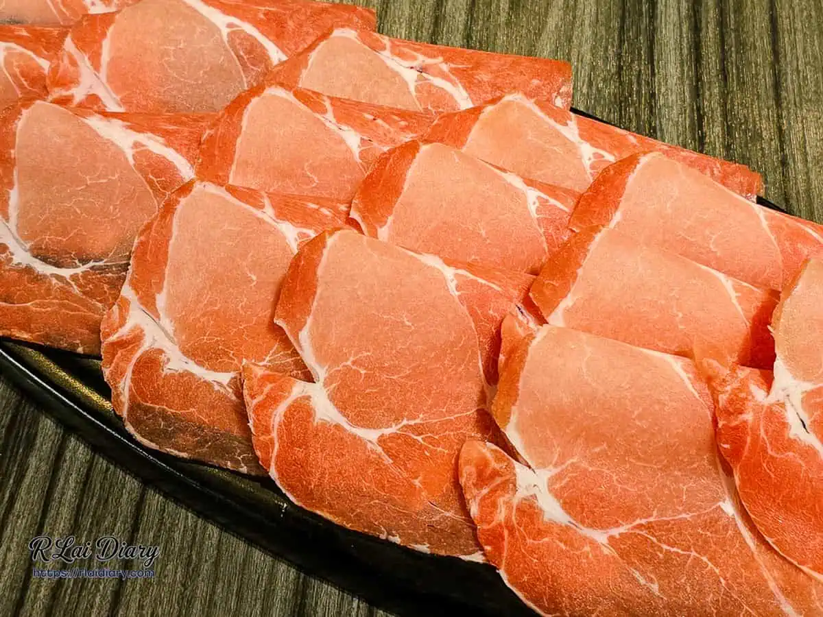 梅花豬肉片特寫，油花分布均勻，展現肉品新鮮度