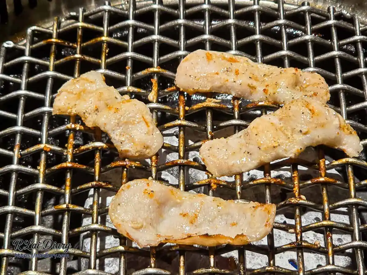 山鯨燒肉炭烤西班牙松阪豬，肉片邊緣微捲，表面烤出金黃焦脆色澤