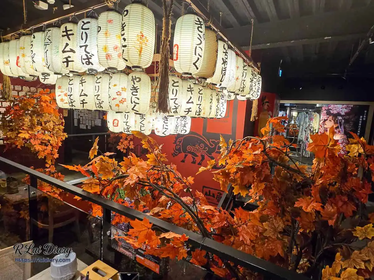 山鯨燒肉店內秋季楓葉造景與整排日式紙燈籠，遠處可見和服體驗區