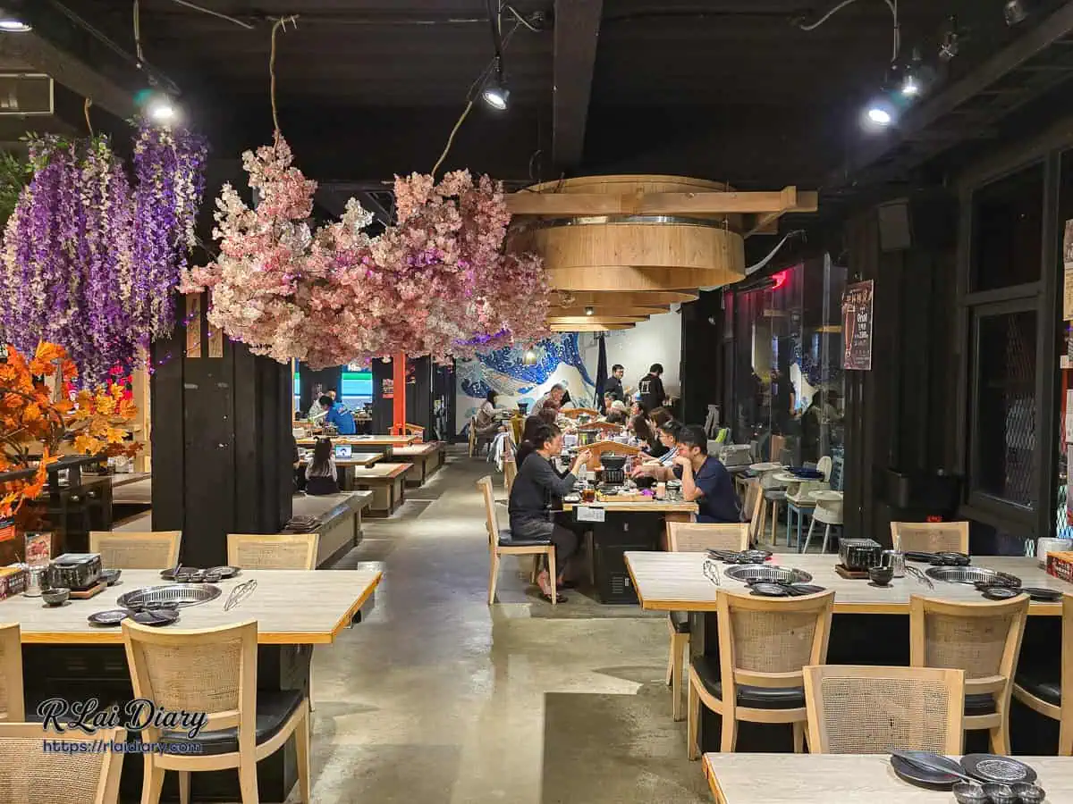 山鯨燒肉漢口店寬敞舒適的用餐座位區，天花板懸掛著極具視覺震撼的粉嫩櫻花與浪漫紫藤花造景